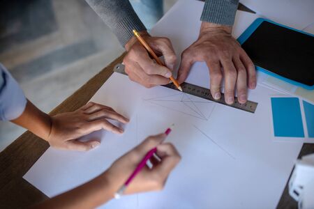 Sketches together. Top view of man and woman making sketches together using pencil and rulerの写真素材