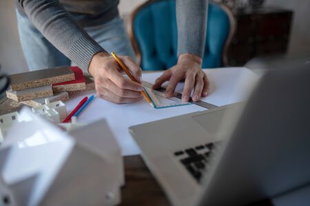 Pencil and ruler. Close up of creative man using ruler and pencil while making sketchesの写真素材