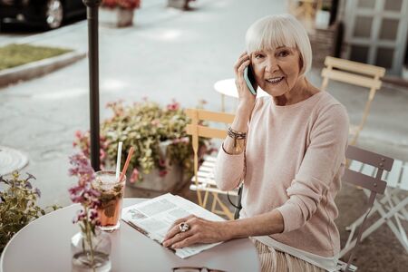 Mobile communication. Joyful elderly woman smiling while making a phone callの写真素材
