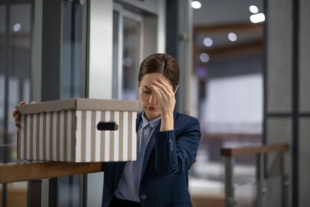 Worker having headache. Dark-haired office worker having headache after been fired from work for no reasonの写真素材