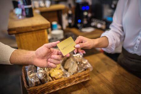 Cashier taking card. Cashier taking card while customer paying for order in cafeteria by card