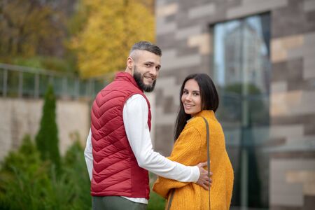 Pleasant couple. Delighted young people smiling while turning to youの写真素材