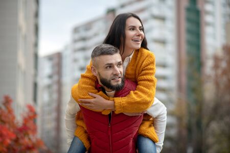 So much fun. Nice young woman holding on to her boyfriend while being held by himの写真素材
