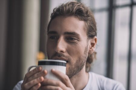 Let the morning begin. A handsome young man starting his day with a cup of coffeeの写真素材