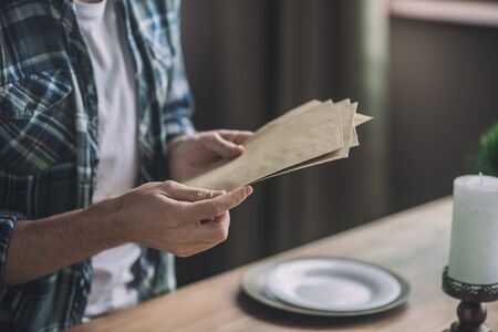 Holding craft envelope. Man holding pieces of old craft paperの写真素材