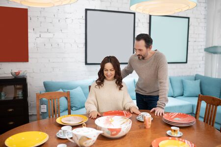 Good stuff. Man and woman in light sweaters looking interestedの写真素材