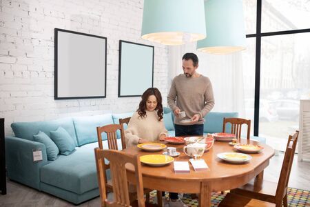 Modern interior. Happy couple examimimg furniture in a light roomの写真素材