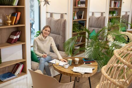 Favourite workplace. A smiling young woman working with her laptop in the cafe
