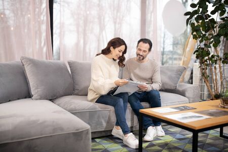 Feeling comfortable. Man and woman in furniture salon sitting on a comfortable sofaの写真素材