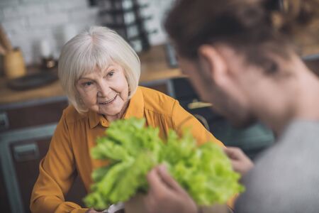 Salad. Young man holding greens in his hands