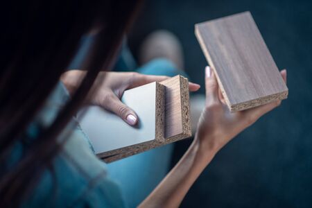 Wooden materials. Top view of three different wooden bricks being in female hands