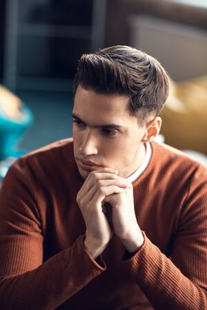 Man feeling thoughtful. Handsome young man feeling thoughtful while having too much work to do