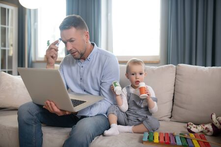 Busy day. Single father looking serious working from home