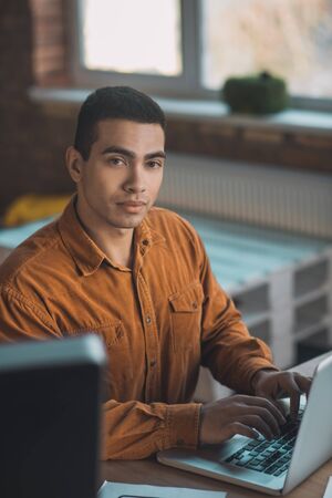 Day in the office. Handsome smart man working while sitting at his workplaceの写真素材