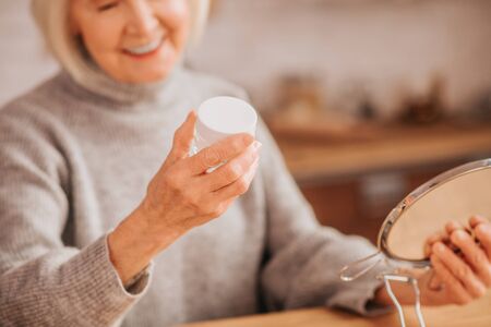 Good mood. Grey-haired beautiful lady in grey blouse feeling goodの写真素材