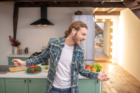 Good mood. A man singing and dancing in the kitchenの写真素材