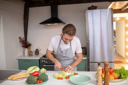 Cooking with pleasure. A man cutting cabbage for a tasty salad