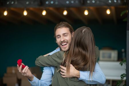 Just engaged. A woman hugging a smiling man after receiving a proposalの写真素材