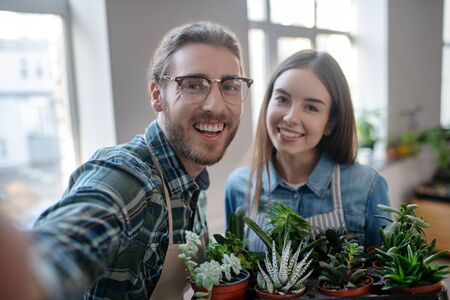 Cute selfie. Man and woman making selfie with various plantsの写真素材