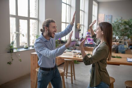 Happy moment. A joyful man and woman clapping their handsの写真素材