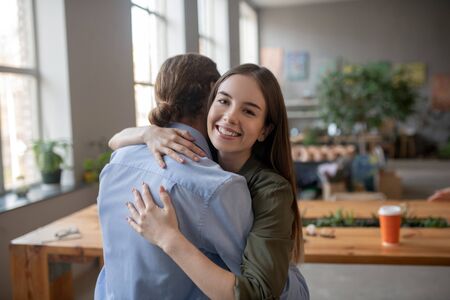 Being friends. A smiling woman hugging a man in a friendly wayの写真素材