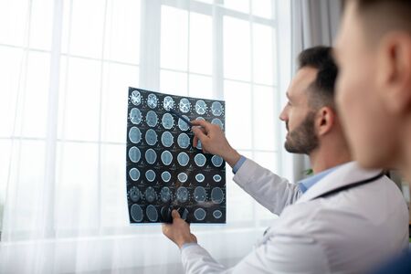 Neurologists. Two male doctors looking interested while analyzing MRI resultsの写真素材