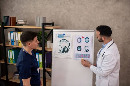 Medical case. Two young neurologists discussing the medical case