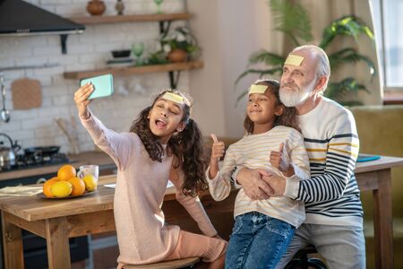 Great time. Grey-haired bearded man and his granddaughters looking cheerful