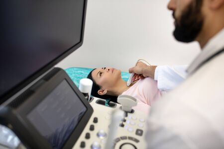 Diagnostics. Asian woman laying on the couch having ultrasonic investigation