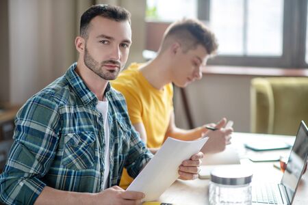 Busy day. Two young men working together on the project and looking seriousの写真素材