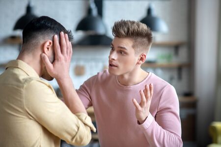 Argument. Dark-haired bearded man holding hishead looking desperateの写真素材
