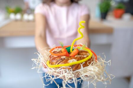 Nicely decorated. Close up picture of girls hands holding easter bun