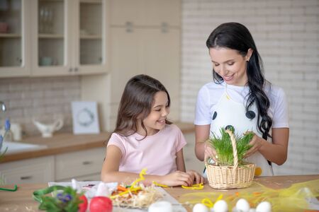 Busy in the kitchen. Mom and daughter getting easter basket ready and looking busy