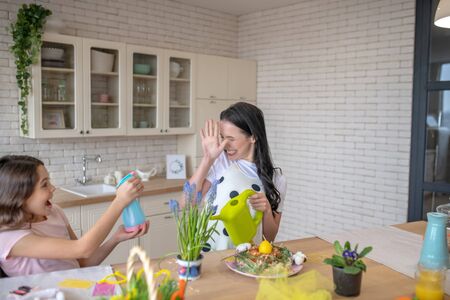 Having fun. Brunette woman and her pretty daughter having fun in the kitchenの写真素材