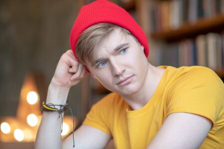 Looking sad. Young man in a red hat looking sadの写真素材