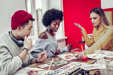 Listen to me. Attentive international people being in all ears while visiting art workshopの写真素材