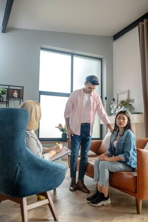 Being sorry. Dark-haired tall man standing next to his girlfriendの写真素材