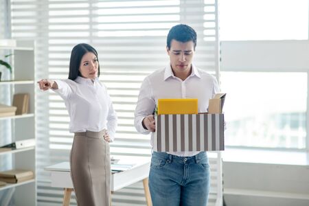 Angry boss. Angry manager showing to the door to her unhappy employee
