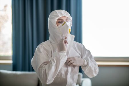 Facial mask. Woman in white workwear wearing protective maskの写真素材