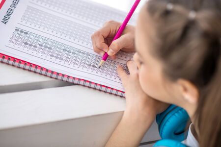 Writing. Girl with long hair writing something in her notebook