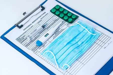 In clinic. Close up picture of medication form and thermometer, pills and syringe