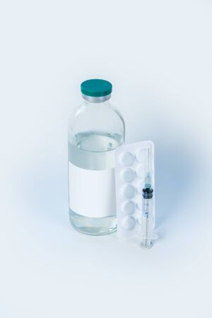 Medical equipment. Bottle of sterile liquid with syring and pillsの写真素材
