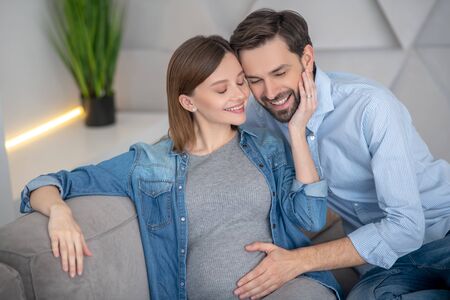 Happy couple. Young pregnant woman feeling happy with her husbandの写真素材