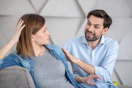 Closeness. Young bearded man touching his wifes shoulder and smilingの写真素材