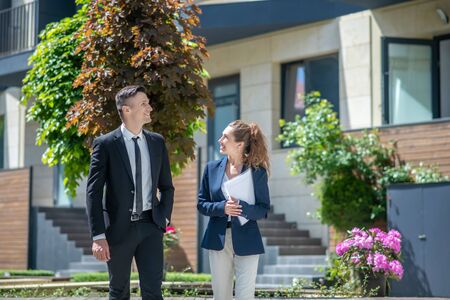 Female broker showing houses with apartments for rent to the client and talking to himの写真素材