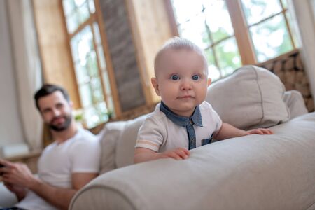 Cute baby. Cute baby crowling , his father watching him and smilingの写真素材