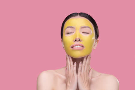 Lifting mask. A young woman using a new effective facial maskの写真素材