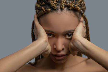 Inner pain. Frustrated young African American woman covering her ears with handsの写真素材