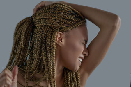 Inner pain. Devastated young African American holding her head with one arm, frowning with painの写真素材