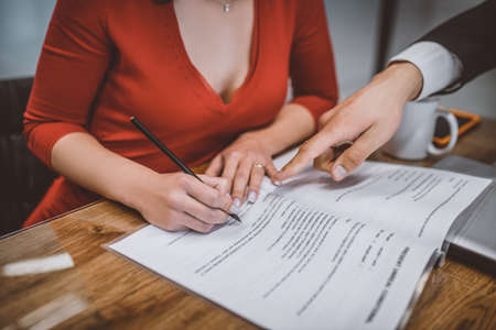 Important document. A woman filling a paper with lawyers helpの写真素材